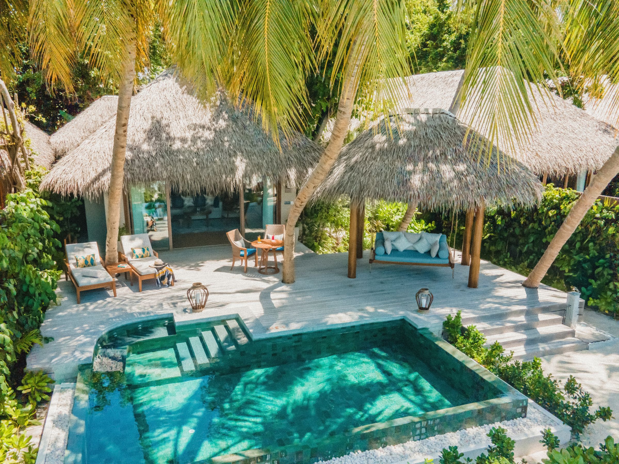 Thatched gazebo, deck and private pool of the Baros Suite, among palm trees