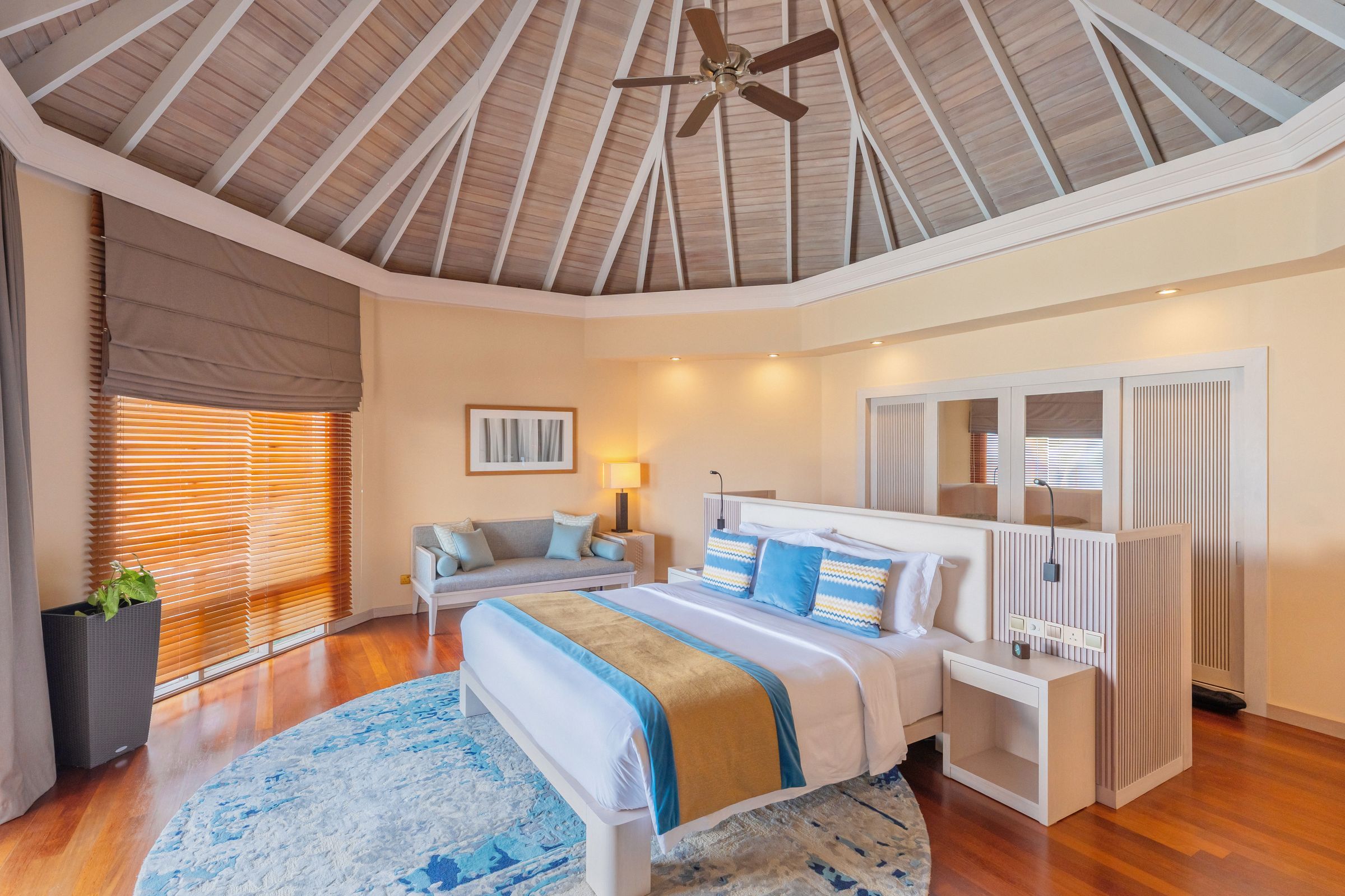 Spacious bedroom of a Water Villa under a high timber ceiling