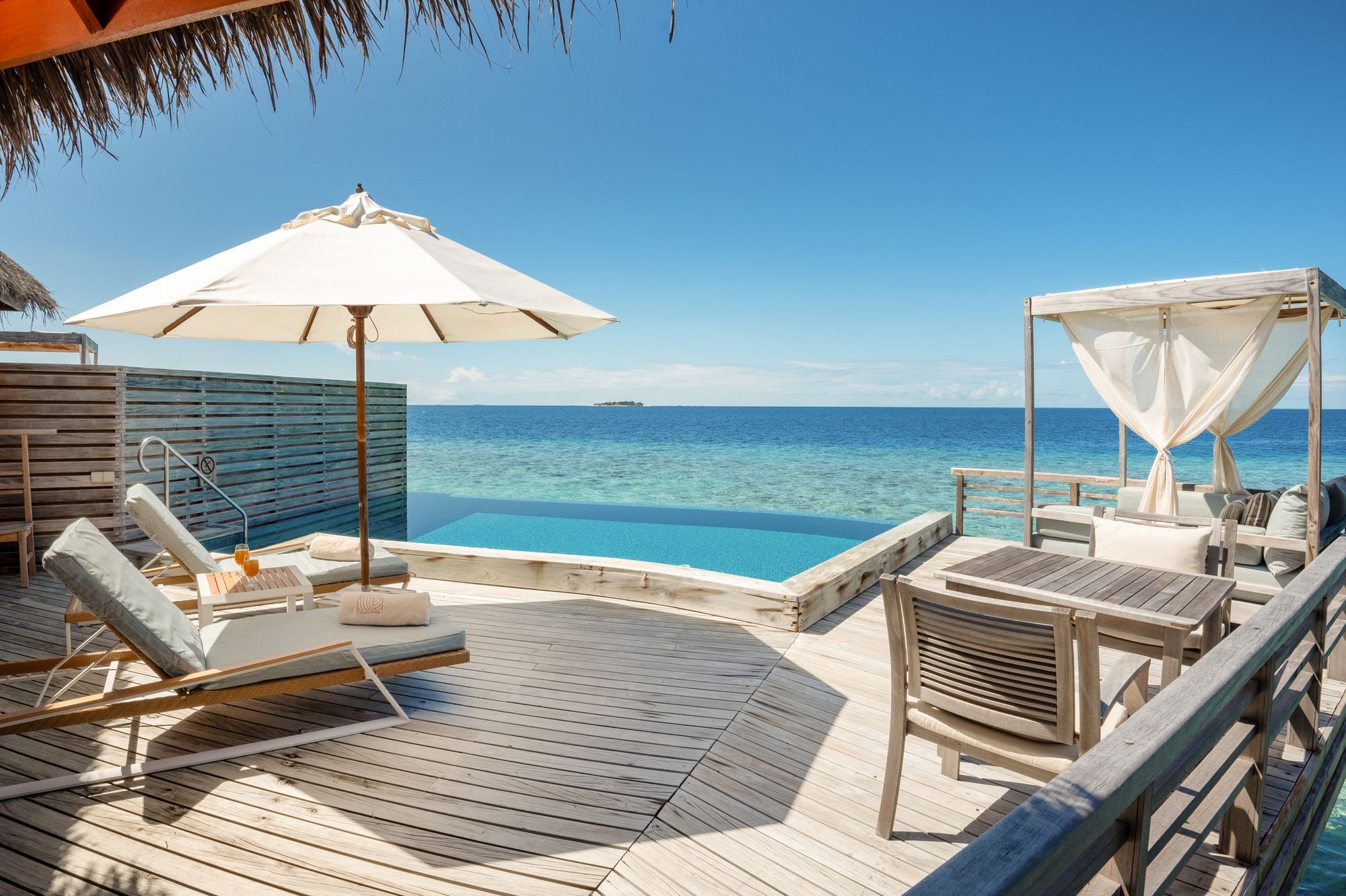 Deck, sun loungers and private pool of a Water Pool Villa above the turquoise lagoon